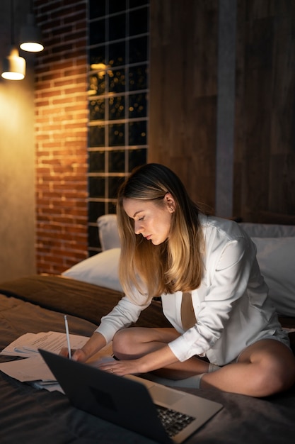 Gratis foto volledig geschoten vrouw die 's avonds laat aan het werk is