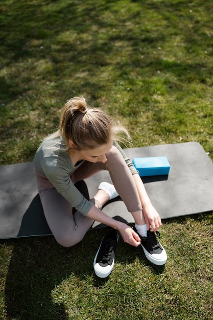 Gratis foto volledig geschoten vrouw die schoenen aantrekt