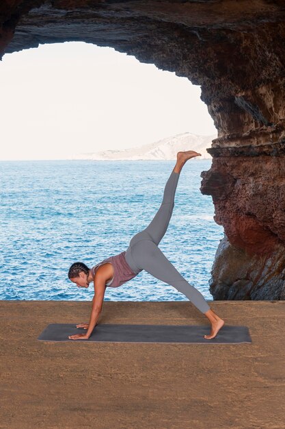 Volledig geschoten vrouw die yoga pose doet