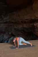 Gratis foto volledig geschoten vrouw doet yoga pose op mat
