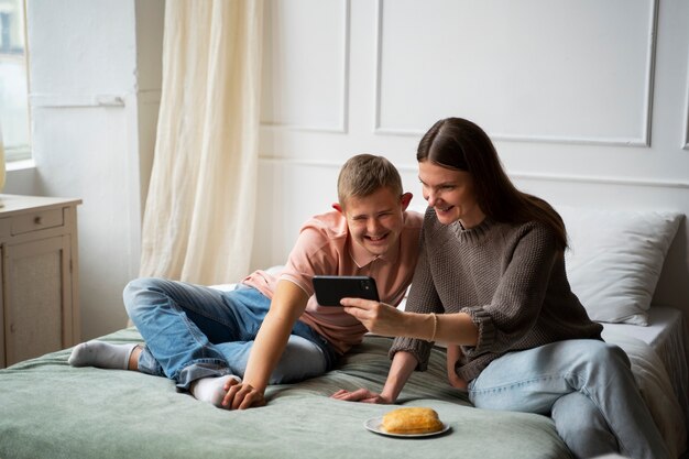 Volledig geschoten vrouw en jongen met smartphone