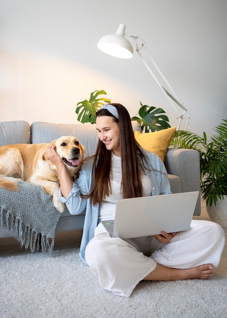 Volledig geschoten vrouw en schattige hond thuis