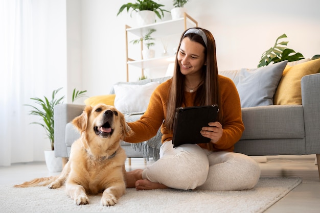 Volledig geschoten vrouw en schattige hond thuis