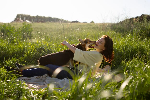 Volledig geschoten vrouw met hond in de natuur