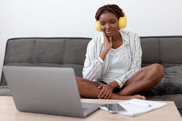 Volledig geschoten vrouw met laptop thuis