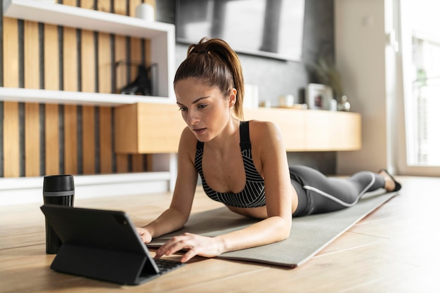 Volledig geschoten vrouw op mat met tablet