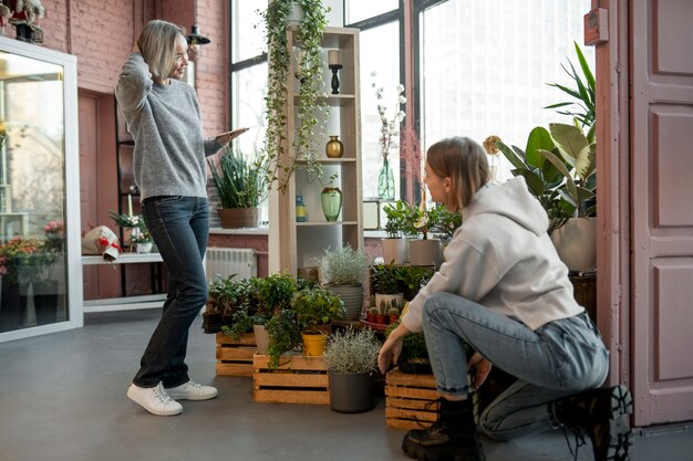 Volledig geschoten vrouwen die bij bloemenwinkel werken