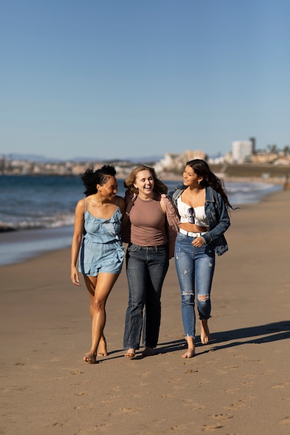 Gratis foto volledig geschoten vrouwen die bij strand lopen