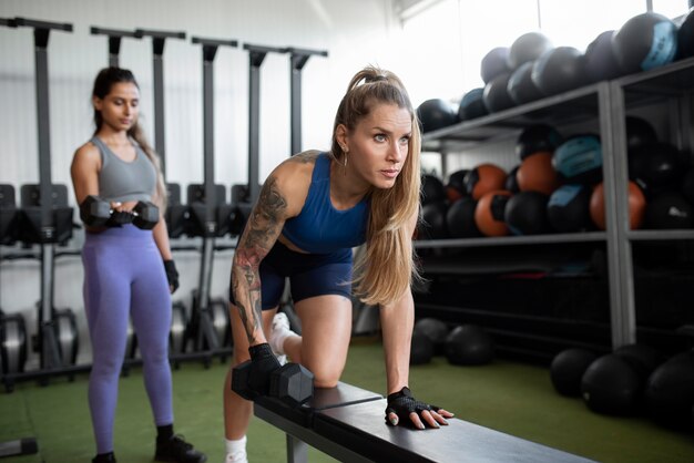 Volledig geschoten vrouwen die met dumbbells trainen