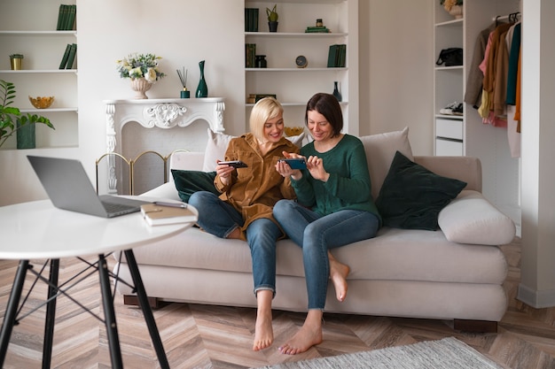 Volledig geschoten vrouwen die met hun telefoon spelen