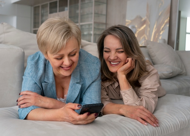 Volledig geschoten vrouwen die mobiele berichten lezen