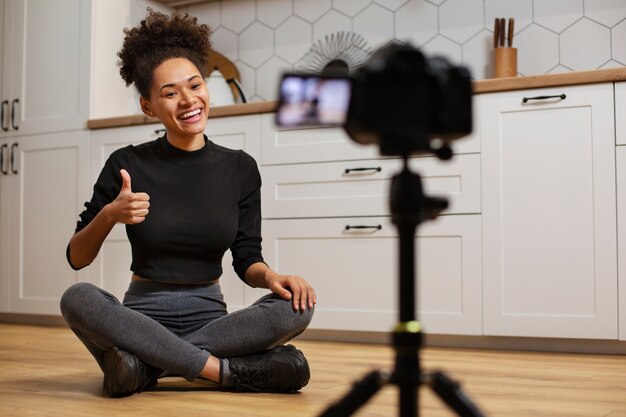 Volledig geschotene smileyvrouw met videocamera