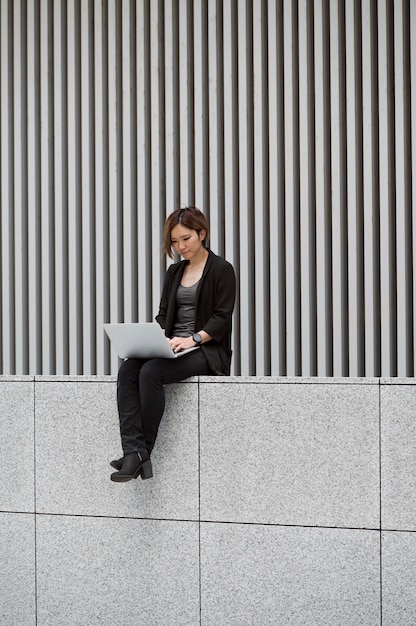 Gratis foto volledig geschotene vrouw die aan laptop werkt