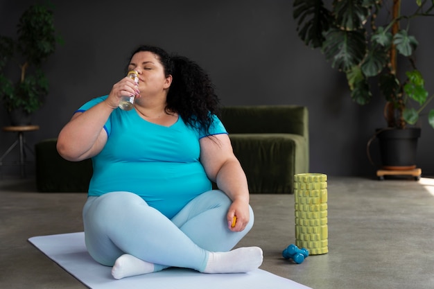 Gratis foto volledig geschotene vrouw die bij gymnastiek uitoefent