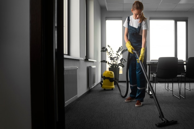 Gratis foto volledig geschotene vrouw die binnenshuis schoonmaakt