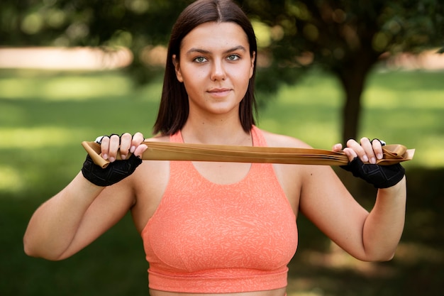 Volledig geschotene vrouw die elastische band houdt