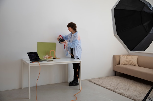 Gratis foto volledig geschotene vrouw die in fotostudio werkt