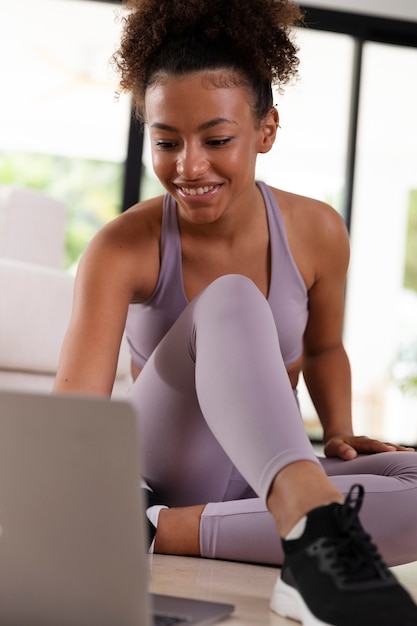 Volledig geschotene vrouw die met laptop zit