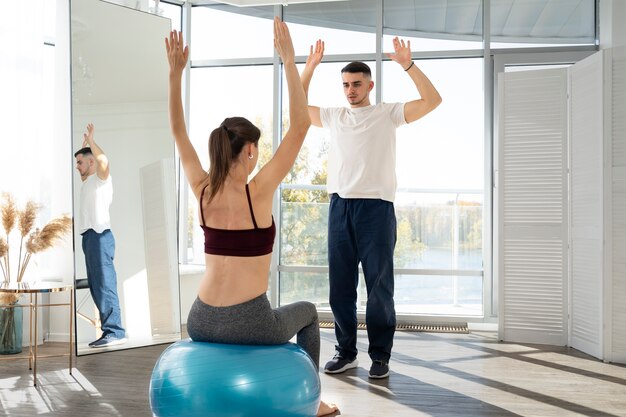 Volledig geschotene vrouw die op gymnastiekbal uitoefent