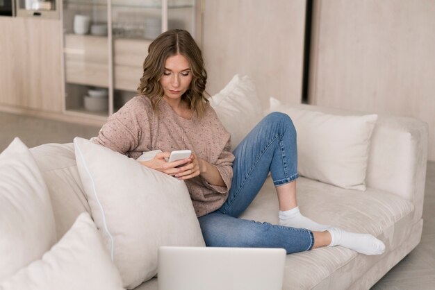 Volledig geschotene vrouw die smartphone bekijkt