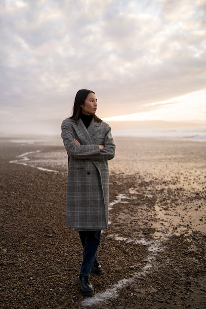 Gratis foto volledig geschotene vrouw die van tijd genieten bij strand