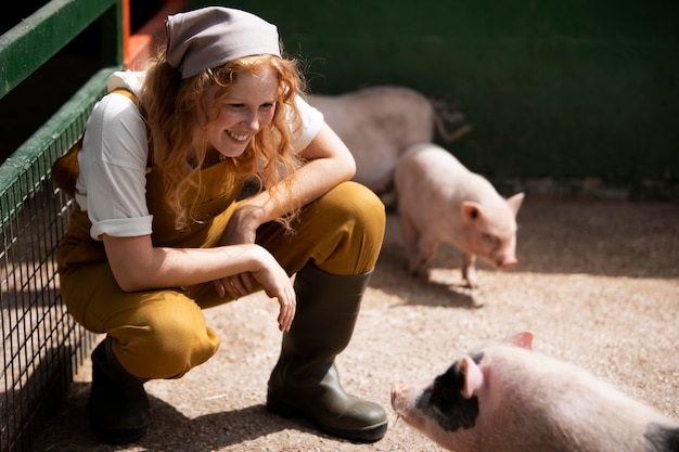 Volledig geschotene vrouw die varkens bekijkt