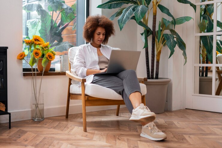Gratis Foto volledig geschotene vrouw met laptop en zonnebloemen