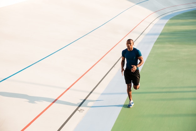 Volledig lengteportret van het geschikte jonge sportman lopen