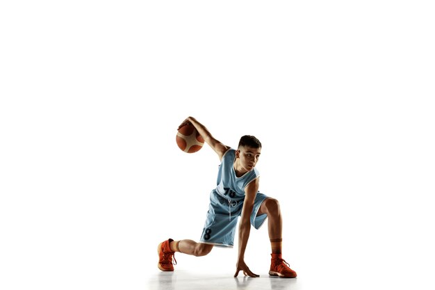 Volledig lengteportret van jonge basketbalspeler met een bal die op witte studioachtergrond wordt geïsoleerd. Tiener training en oefenen in actie, beweging. Concept van sport, beweging, gezonde levensstijl, advertentie.