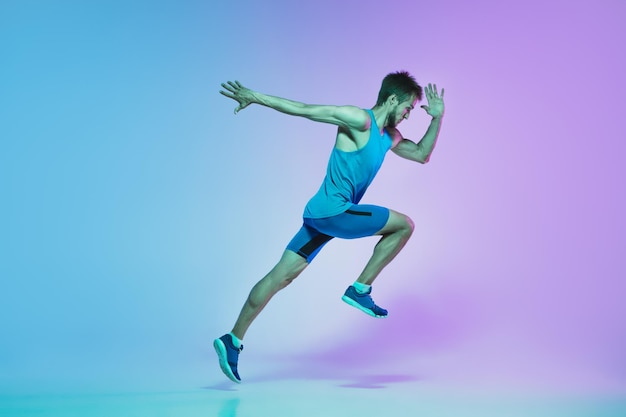 Volledig portret van actieve jonge blanke rennende, joggende man in neon