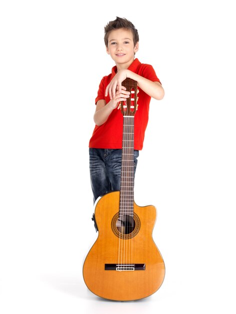 Volledig portret van Kaukasische jongen met akoestische gitaar die op wit wordt geïsoleerd