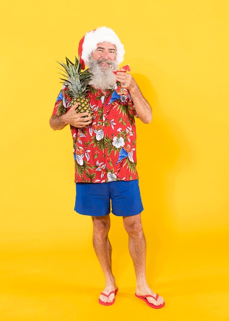 Volledig schot van de mens met tropisch overhemd en kerstmuts