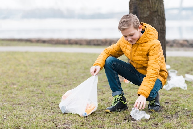 Volledig schot van jongen die de grond schoonmaakt