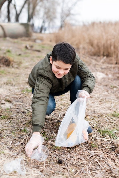 Gratis foto volledig schot van jongen die de grond schoonmaakt