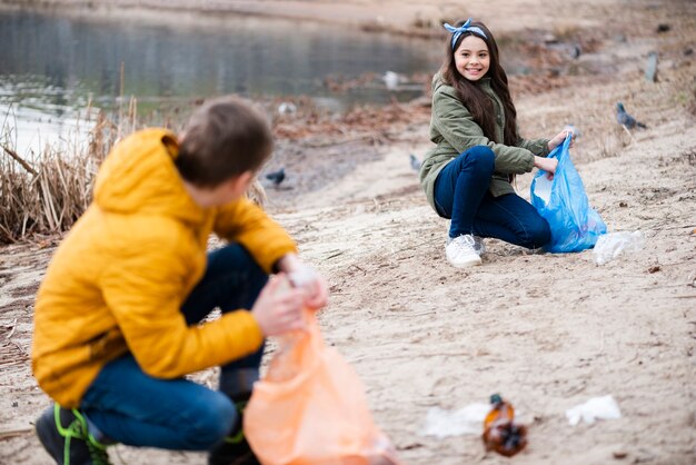 Volledig schot van kinderen die de grond schoonmaken