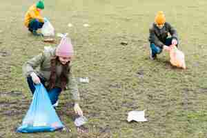 Gratis foto volledig schot van kinderen die de grond schoonmaken