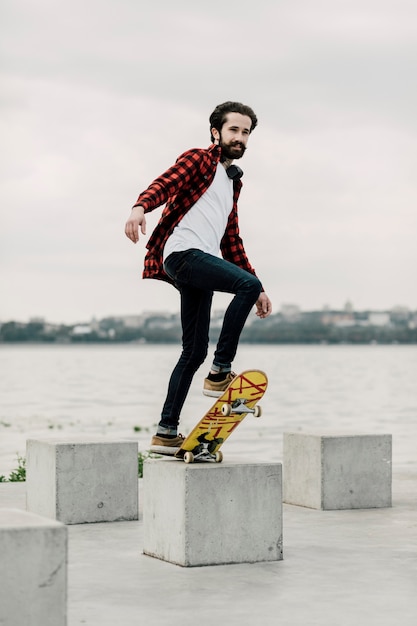 Gratis foto volledig schot van mens het in evenwicht brengen op skateboard