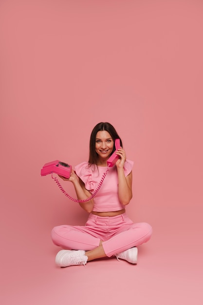 Volledige foto van een vrouw die poseert in een roze outfit