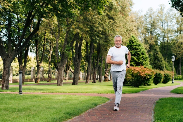 Volledige geschoten oude mens die in aard loopt