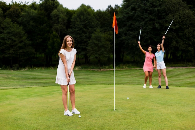 Volledige geschotene groep meisjes die golf spelen