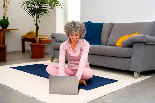 Volledige geschotene smileyvrouw met laptop