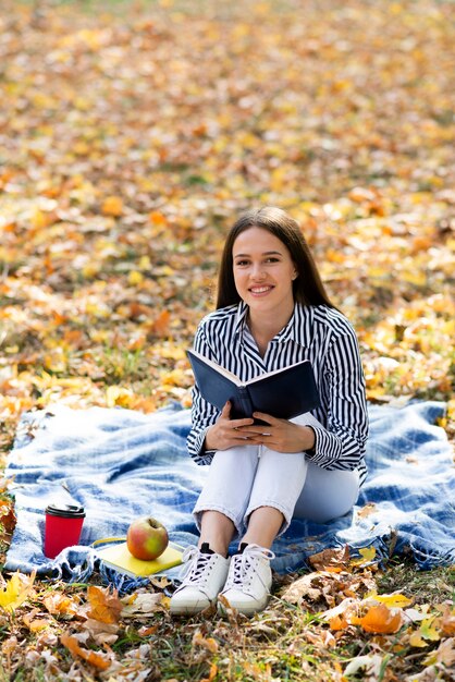 Volledige geschotene vrouw die een boek houdt