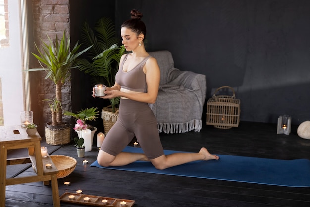 Volledige geschotene vrouw die yoga binnen doet