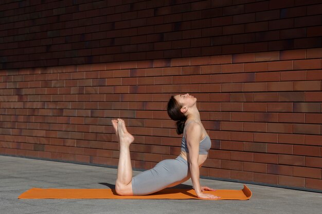 Volledige geschotene vrouw die yoga op mat doet