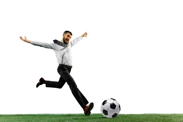 Volledige lengte die van een jonge zakenman speelvoetbal is ontsproten die op witte achtergrond wordt geïsoleerd.