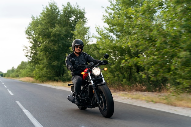 Gratis foto volledige schot man met motorfiets buiten