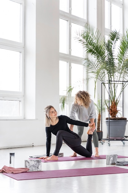 Volledige shot vrouw beoefenen yoga op de mat