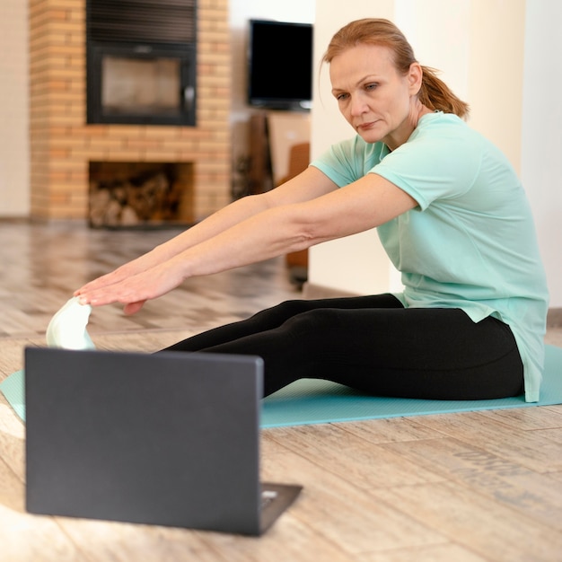 Volledige shot vrouw training met laptop