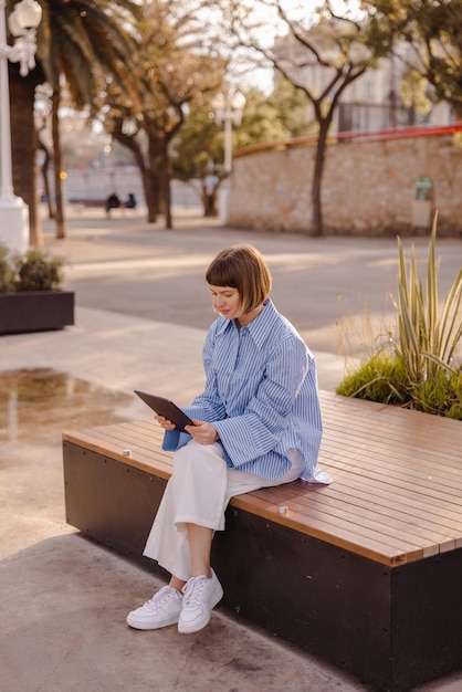 Volledige weergave van schattige vrouw die naar tablet kijkt