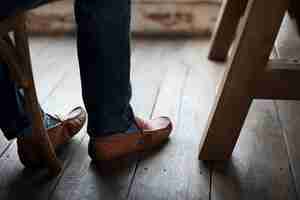 Gratis foto volwassen man benen voeten door de houten vloer